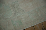 The hand-knotted texture and even wear of a distressed Oushak carpet's low pile.