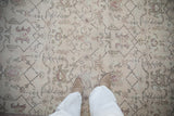 Worn low-pile texture and faded geometric floral design of a vintage distressed Oushak carpet.