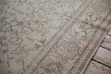Distressed low pile and faded cartouche border on the corner of a vintage Oushak carpet.