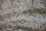 A soft fold in the vintage Oushak carpet reveals its low, hand-knotted texture.