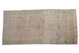 Vintage Oushak runner with a distressed large-scale pattern in pale rose, sand, and dusty teal.