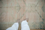 Distressed texture and heavy abrash on a hand-knotted Oushak runner in pale rose and dusty teal.