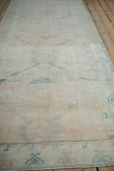 Low angle view along a distressed Oushak runner, showing the soft, evenly worn pile.