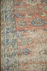 Vintage distressed Oushak rug's blush field and border with faded palmette motifs.