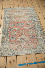 Close-up of distressed dusty rose and pale ivory Oushak rug pile, foundation showing through.