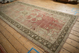 Vintage distressed Oushak runner, abrashed blush field, sand geometric motifs, olive border.