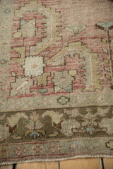 Faded blush, beige, olive, and red geometric floral patterns with abrashes on this Oushak rug.