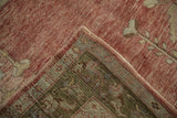 Distressed Oushak rug runner's folded corner reveals abrashed dusty blush pile and geometric foundation.