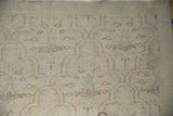 Worn Oushak rug pile with distressed trellis, floral palmette, dusty pink, and pale mint green.