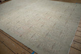 Faded pink and mint floral trellis patterns on the low pile of this distressed Oushak carpet.