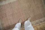 Faded pile texture of a distressed vintage Oushak rug in coffee brown and blush.