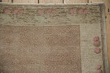 Distressed Oushak rug with even wear, showing pale coffee brown pile and blush blossoms.