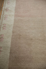 Distressed vintage Oushak rug detail: low pile, pale coffee brown field, and soft blush floral border.