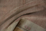 Distressed vintage Oushak rug pile in pale coffee, blush, and ivory tones, folded to show texture.