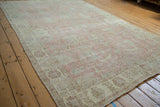 Vintage distressed Turkish Sparta carpet with faded pink and ivory floral pattern.
