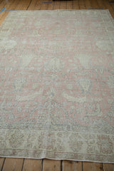Distressed blush and ivory floral pattern with slate blue accents on a vintage Sparta carpet.
