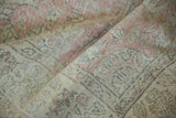 Distressed texture showing worn pink, ivory, and slate blue floral motifs.