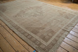Distressed Oushak carpet corner, with pale beige, coffee brown spandrel and textural patterns.