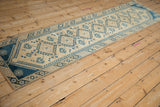 Distressed Dosemealti rug corner, beige field, blue crab-style floral gul, hook-and-latch border.