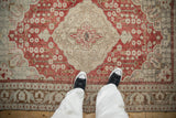 A personal view looking down at the distressed texture and ivory medallion of a vintage Kayseri rug.