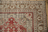 Close-up of a vintage Kayseri rug corner showing stylized motifs and a distressed, low-pile texture.