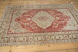 Corner perspective of a distressed Kayseri rug, featuring slate blue spandrels and a cherry red floral field.