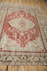 Low angle view showcasing the distressed texture and scalloped medallion on a vintage Kayseri rug.