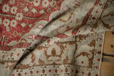 Soft folds of a distressed Kayseri rug showing the low pile and time-softened red and blue hues.