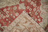 Corner of a vintage distressed Kayseri rug folded to show the woven foundation and secured edge.