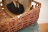 Antique splint oak basket with dark patina, visible white paint, and separated woven slats.