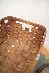 Interior of the antique splint oak basket, showing dark patina and visible broken slats.