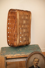 Side view of antique splint oak basket, showing woven texture and dark patina.