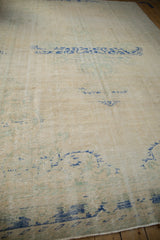 Faded cream and cobalt blue patterns with heavy wear on a vintage Oushak carpet.