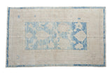 Distressed Oushak rug, aquatic blue floral motifs and abrashes on an ivory field.