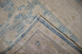 Distressed Oushak rug showing its hand knotted reverse and original side selvage.