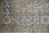 Turkish Sparta rug corner with faded rose and denim blue floral border.