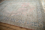 Distressed vintage Sparta rug showing abrashed dusty rose field and blue meandering floral border.