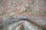 Distressed vintage Sparta carpet pile close-up, showing wear to knot heads and faded patterns in blush, ivory, and green.