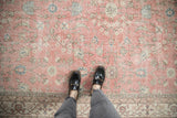 Distressed vintage Turkish Sparta carpet showcasing worn floral vines and meandering border in pink.