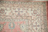 Worn bubblegum pink, ivory, slate floral and vine motifs on distressed Sparta rug corner.
