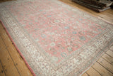 Distressed hand-knotted Sparta carpet: bubblegum pink field, floral motifs, and visible wear.