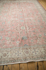 Distressed pink and ivory meandering vine border with machine bound end on vintage Sparta rug.