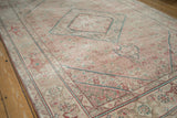Distressed vintage Tabriz rug corner, featuring sand, raspberry red Herati, and subtle teal.