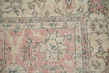 Distressed pink, beige, charcoal floral palmette motifs with visible foundation.