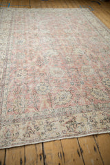 Distressed vintage Sparta carpet corner, showing foundation, pink, ivory, and charcoal floral patterns.