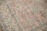 Distressed pink and ivory Sparta carpet detail, showing worn floral design and visible foundation threads.