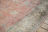 Distressed Sparta rug texture with blush pink field, ivory border, and visible foundation.