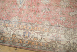 Distressed Sparta carpet detail: worn blush field transitions to a decorative ivory border.