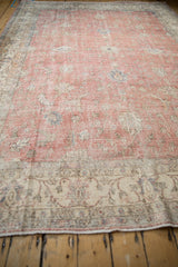 Distressed blush pile and intricate ivory border of a vintage Sparta rug, showing foundation wear.