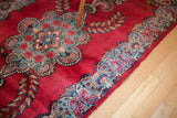 Bold hot pink field and blue curvilinear border of a vintage Persian Kerman rug.